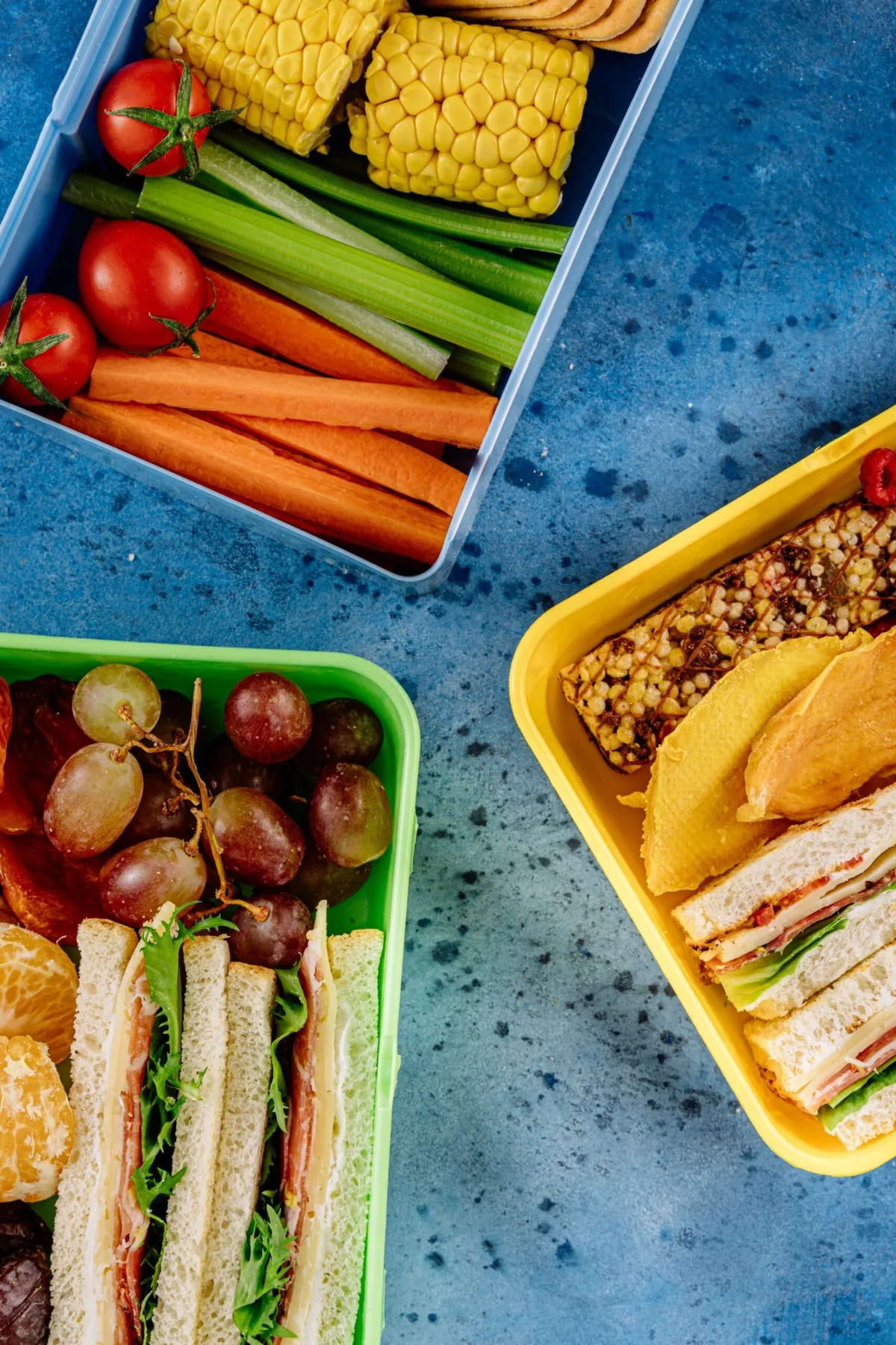 Easy school lunch box with sandwich triangles, tomatoes, cucumber and grapes